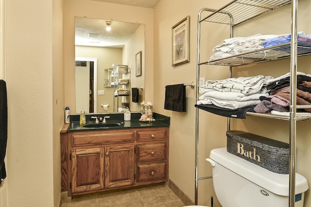 bathroom with tile patterned floors, vanity, and toilet
