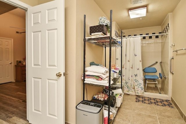 interior space with tile patterned floors, baseboards, and a stall shower