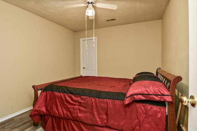 bedroom with wood finished floors, visible vents, a ceiling fan, and baseboards