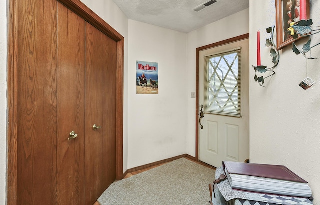 8100 Creek Rd, Hartville, MO 65667 - doorway with a textured ceiling, carpet floors, visible vents, and baseboards