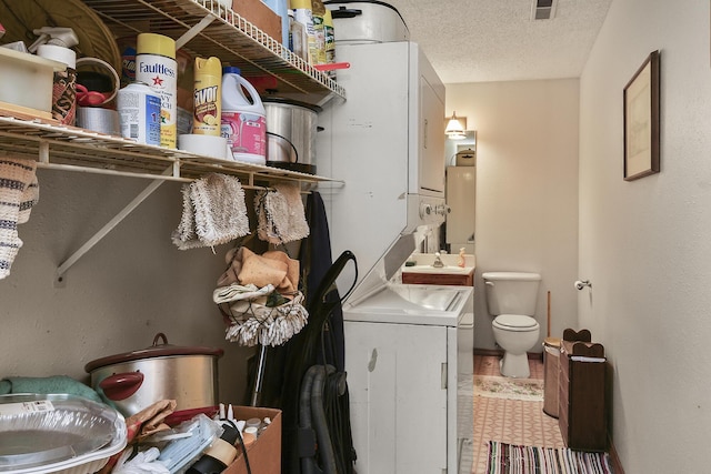 8100 Creek Rd, Hartville, MO 65667 - laundry area with water heater, laundry area, a sink, stacked washer and dryer, and a textured ceiling