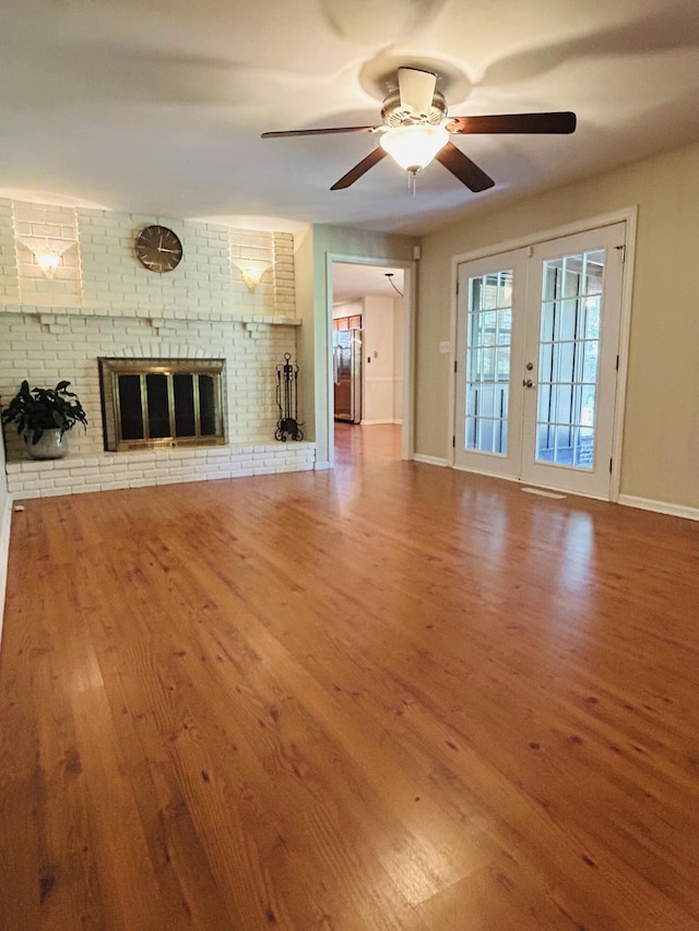 2036 E Greenwood St, Springfield, MO 65804 - unfurnished living room with wood finished floors, ceiling fan, and a brick fireplace