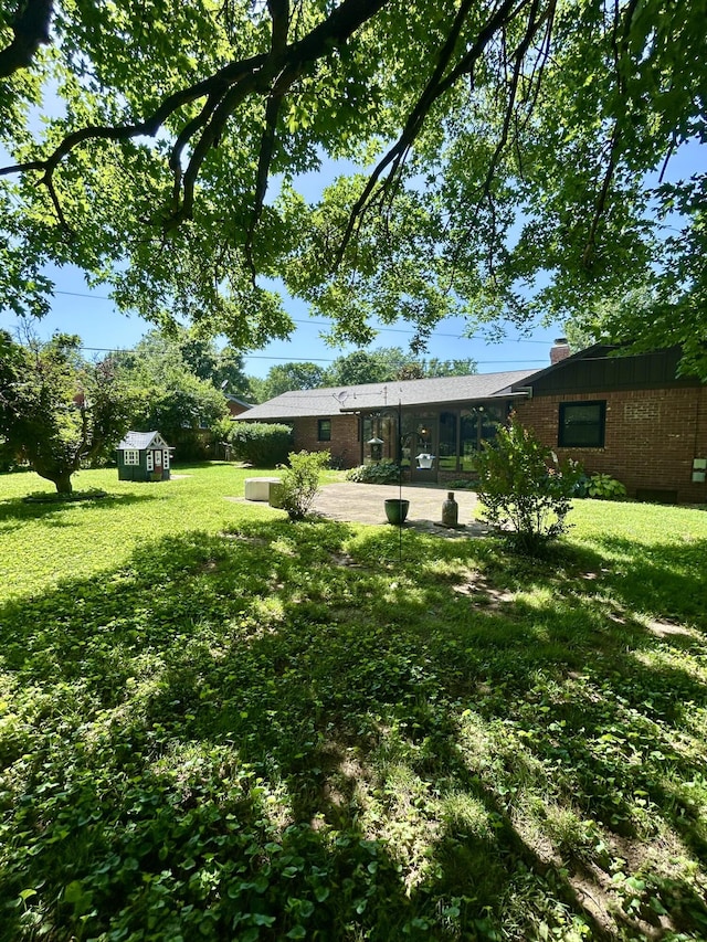 2036 E Greenwood St, Springfield, MO 65804 - view of grassy yard with a storage unit and a patio