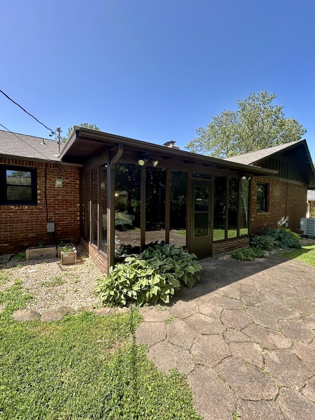 2036 E Greenwood St, Springfield, MO 65804 - rear view of property with brick siding, a patio area, and a sunroom