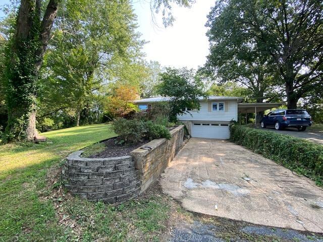 exterior space featuring an attached garage, driveway, and a yard