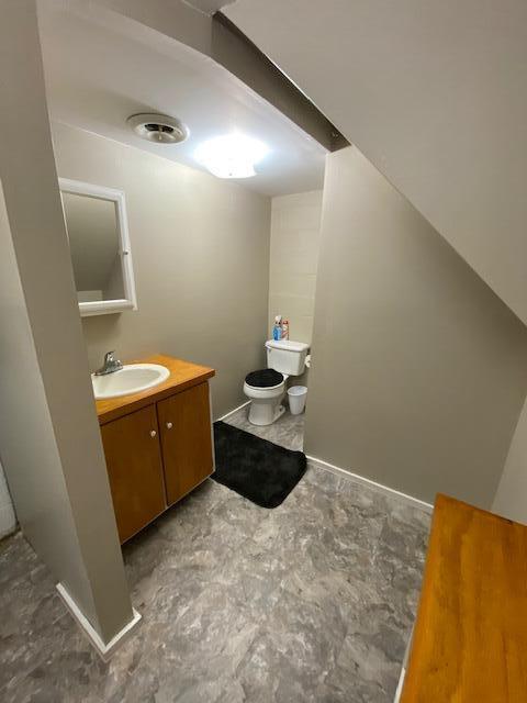 half bathroom with vanity and toilet