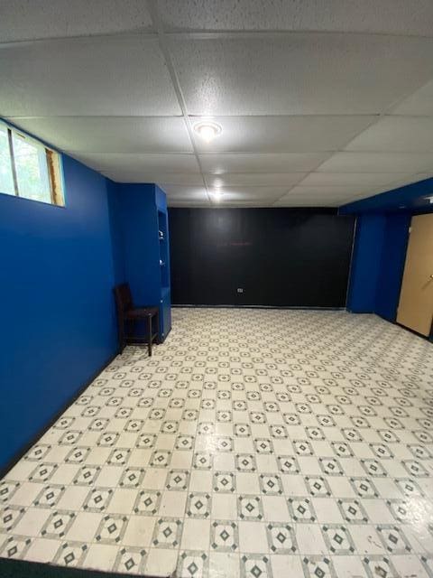 below grade area with light floors and a drop ceiling