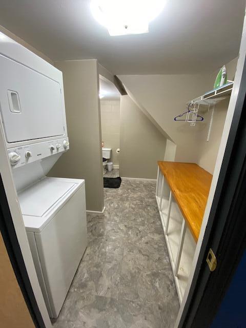 laundry area with stacked washer and clothes dryer and laundry area