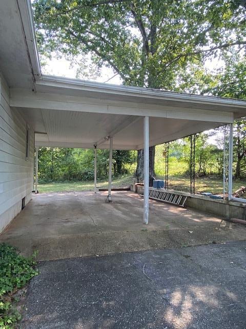 view of parking featuring a carport and aphalt driveway