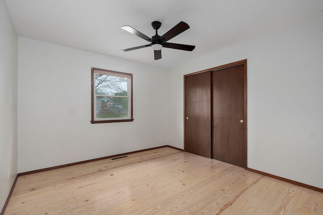 4542 S Holiday Ave, Springfield, MO 65810 - unfurnished bedroom featuring visible vents, a closet, baseboards, light wood-style flooring, and ceiling fan