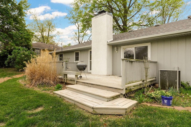 4542 S Holiday Ave, Springfield, MO 65810 - back of property featuring a chimney, a wooden deck, a shingled roof, and a lawn