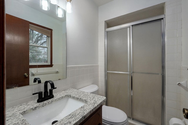 4542 S Holiday Ave, Springfield, MO 65810 - full bath featuring a stall shower, vanity, tile walls, a wainscoted wall, and toilet