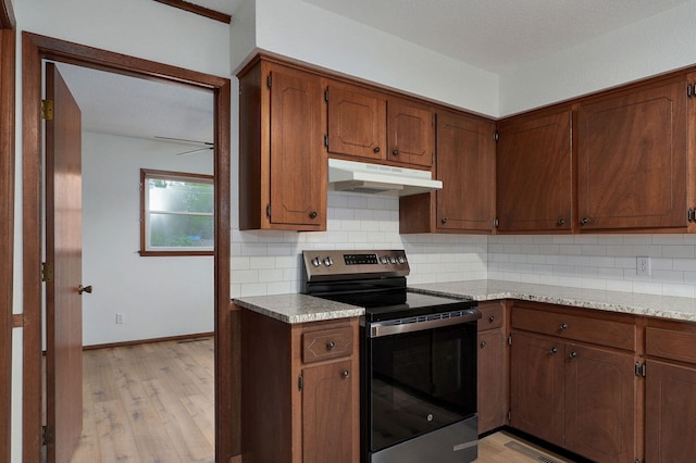 4542 S Holiday Ave, Springfield, MO 65810 - kitchen featuring under cabinet range hood, baseboards, decorative backsplash, stainless steel electric stove, and light wood-style flooring