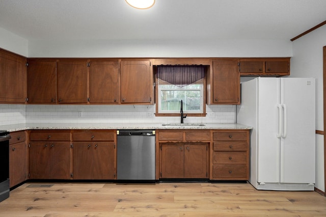 4542 S Holiday Ave, Springfield, MO 65810 - kitchen with stainless steel dishwasher, a sink, decorative backsplash, light countertops, and freestanding refrigerator