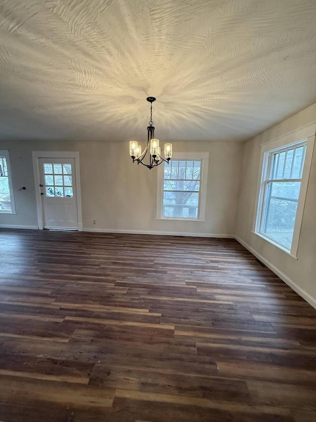 1001 E Pacific St, Springfield, MO 65803 - unfurnished dining area featuring dark wood-style floors, baseboards, and a chandelier