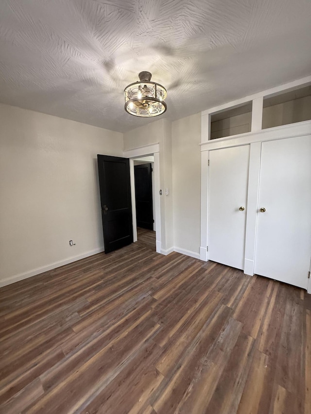 1001 E Pacific St, Springfield, MO 65803 - unfurnished dining area with dark wood finished floors, baseboards, and an inviting chandelier