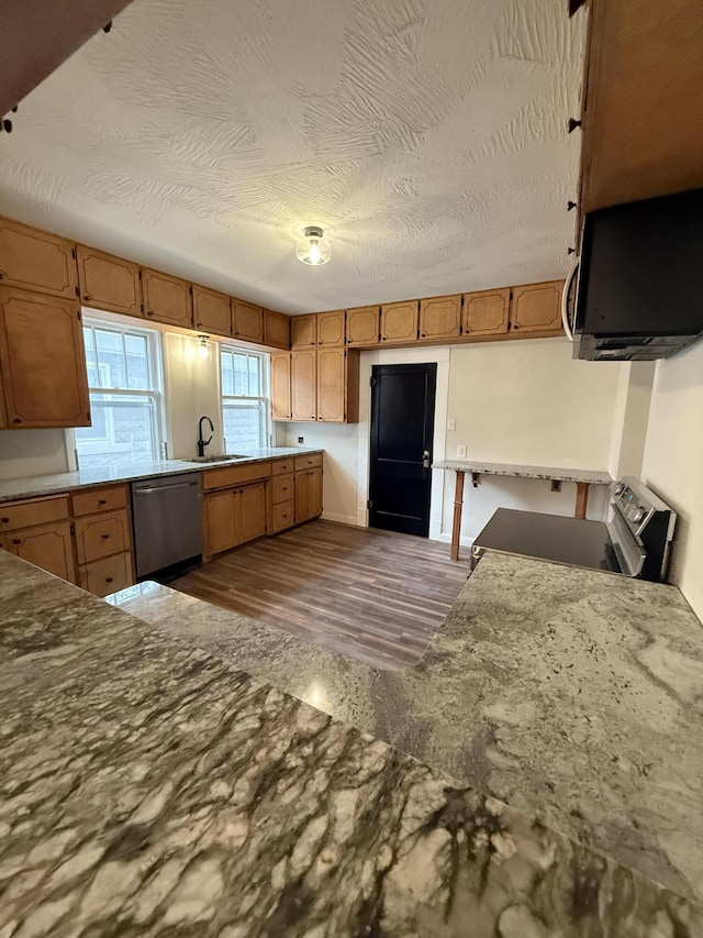 1001 E Pacific St, Springfield, MO 65803 - kitchen with brown cabinets, electric stove, stainless steel dishwasher, a sink, and dark wood-type flooring