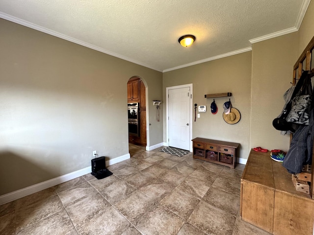 interior space with baseboards, arched walkways, a textured ceiling, and crown molding