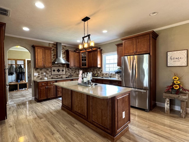 kitchen featuring freestanding refrigerator, wall chimney exhaust hood, tasteful backsplash, visible vents, and black electric cooktop