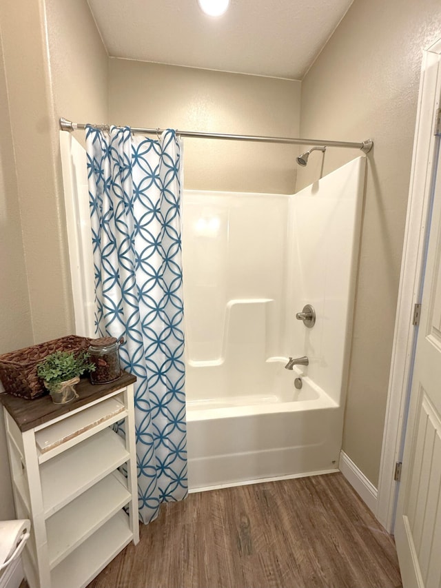 full bathroom with wood finished floors and shower / bath combination with curtain