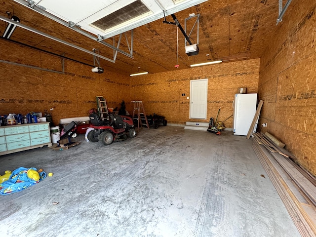 garage with freestanding refrigerator and a garage door opener