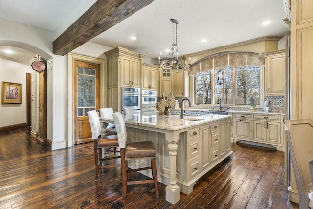 845 W Farm Road 96, Springfield, MO 65803 - kitchen with baseboards, dark wood-style floors, cream cabinets, and a sink