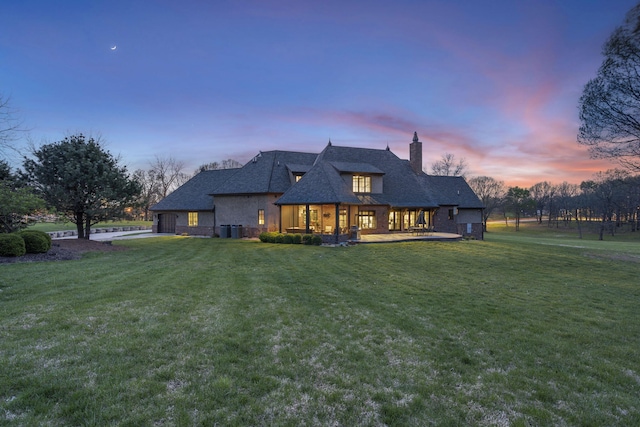 845 W Farm Road 96, Springfield, MO 65803 - rear view of house featuring a chimney, central AC unit, a yard, a porch, and stone siding