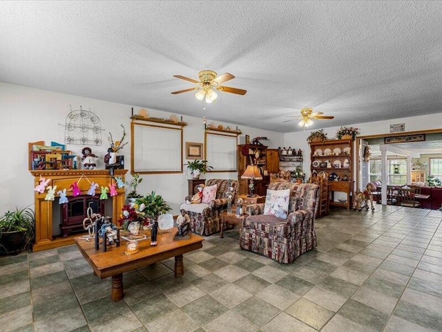 living room with a ceiling fan and a textured ceiling