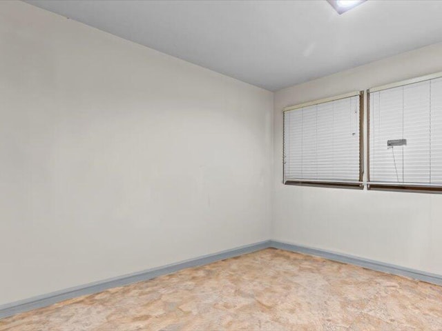 empty room with light colored carpet and baseboards