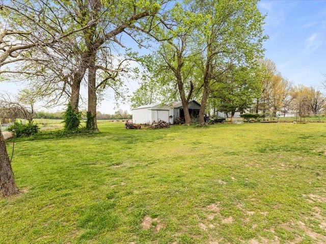 view of yard featuring an outdoor structure and an outbuilding