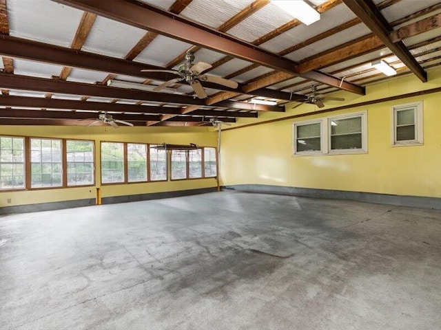 interior space featuring concrete flooring, a ceiling fan, and baseboards