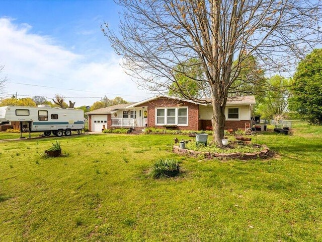 back of property featuring a garage, a yard, and brick siding