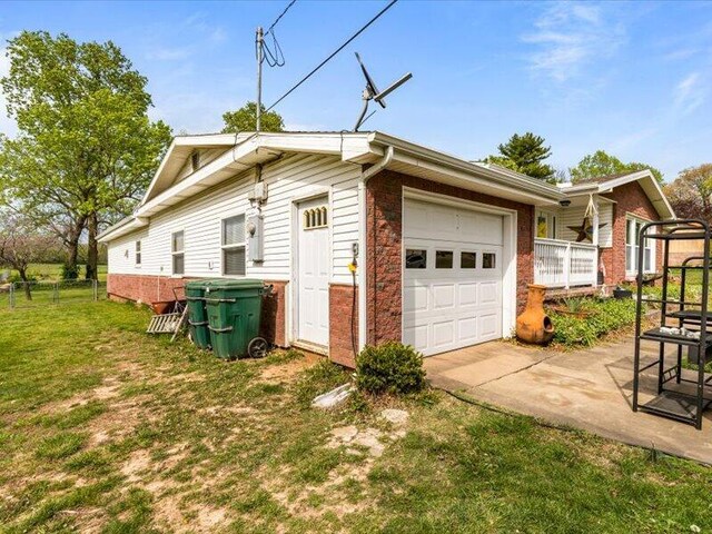 view of property exterior featuring fence, driveway, a yard, and a garage