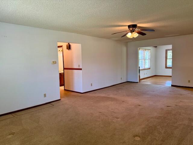 700 Ridgeway, Mountain View, MO 65548 - spare room featuring baseboards, carpet, a textured ceiling, and ceiling fan