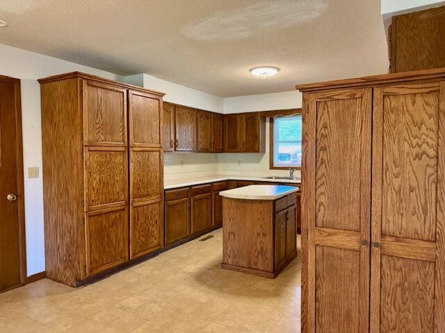 700 Ridgeway, Mountain View, MO 65548 - kitchen featuring light floors, light countertops, a textured ceiling, and a kitchen island