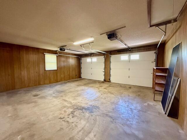 700 Ridgeway, Mountain View, MO 65548 - garage with a garage door opener and wood walls