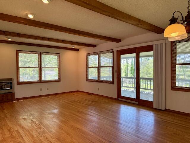 700 Ridgeway, Mountain View, MO 65548 - unfurnished living room with beamed ceiling, light wood-type flooring, baseboards, and heating unit