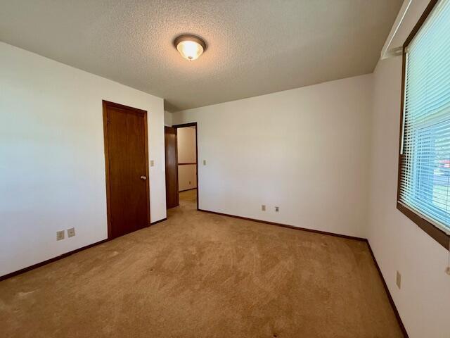 700 Ridgeway, Mountain View, MO 65548 - carpeted spare room featuring a textured ceiling and baseboards