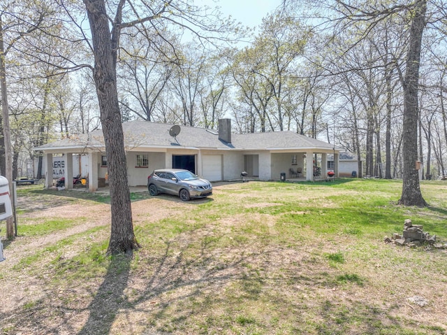 view of front facade featuring a front yard, an attached garage, and a chimney