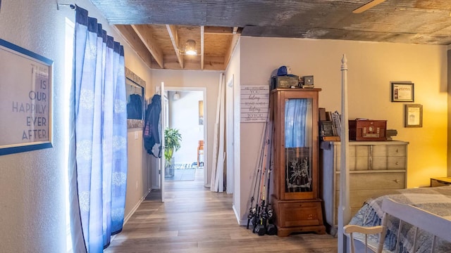 corridor with wood finished floors and baseboards