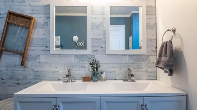 bathroom featuring double vanity, wood walls, and a sink