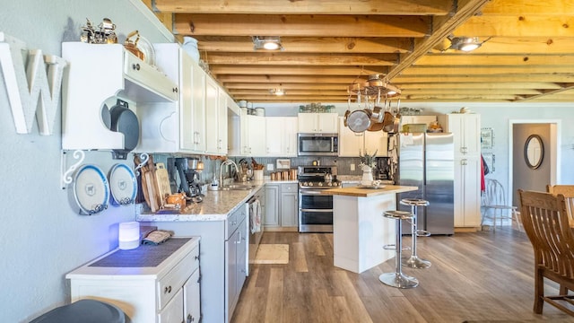 kitchen featuring butcher block counters, wood finished floors, appliances with stainless steel finishes, and a sink