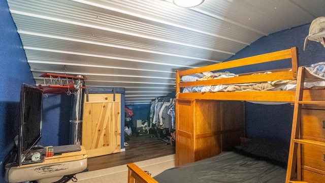 bedroom with lofted ceiling and wood finished floors