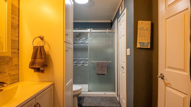 bathroom with crown molding, a shower stall, toilet, and vanity