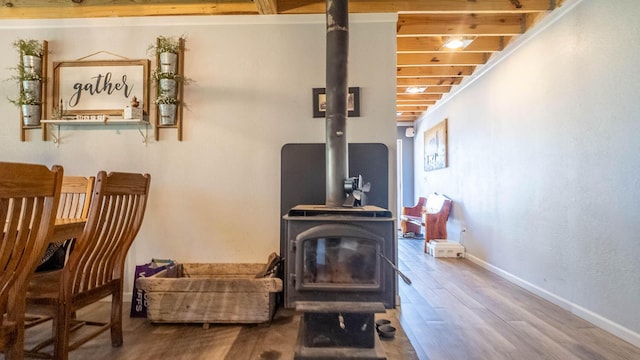 interior space with baseboards, wood finished floors, and a wood stove