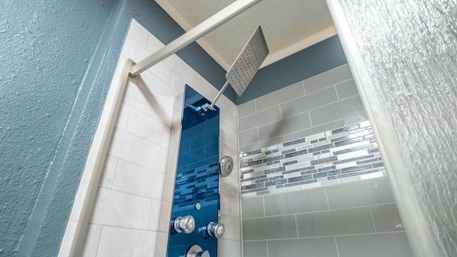 room details with a tile shower and a textured ceiling