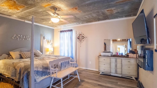 bedroom featuring wood finished floors, crown molding, baseboards, and ceiling fan