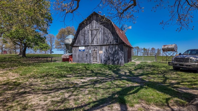 view of barn featuring a lawn and fence