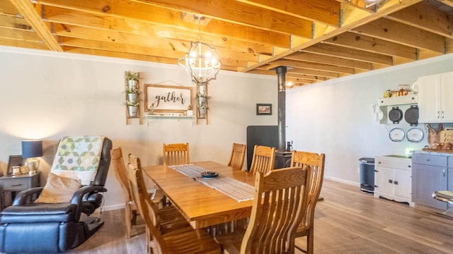 dining room with light wood finished floors, baseboards, and a notable chandelier