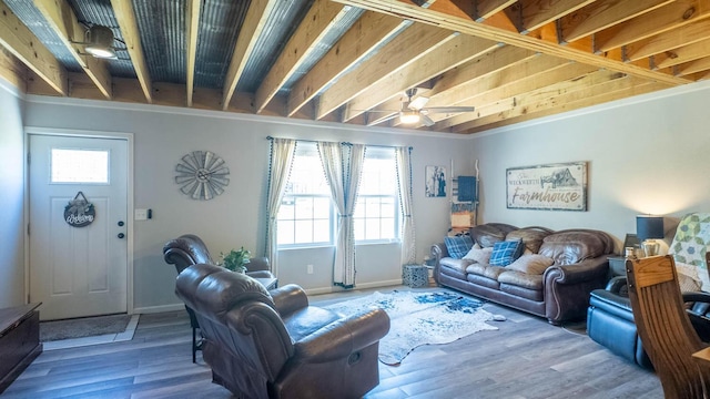 living area featuring baseboards, a ceiling fan, and wood finished floors